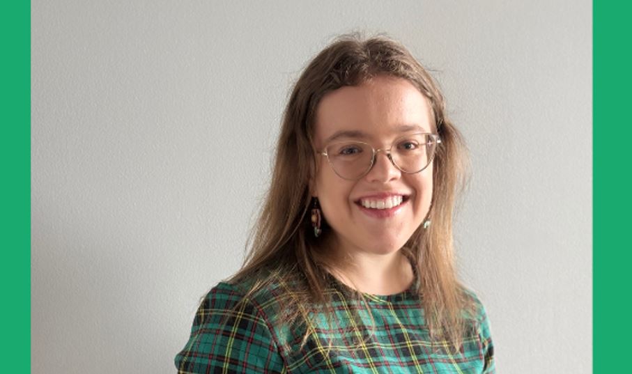 Photo of Julie wearing a green checkered dress and smiling at the camera